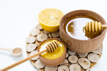 Bowl of honey on white background. Symbol of healthy living and natural medicine. Aromatic and tasty.