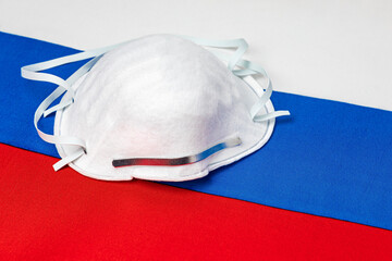 Russia flag and N95 face mask. Concept of Covid-19 coronavirus lockdown, travel ban and healthcare...