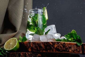 Mojito cocktail on a dark background. Wooden stand.