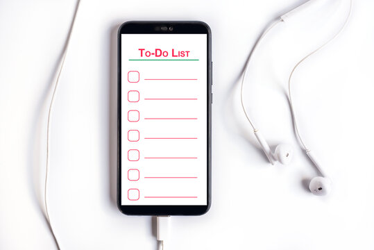 Smartphone with empty to-do list with earphones on a wooden table
