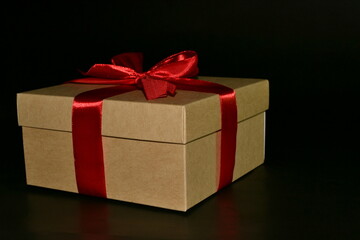 Gift box with red bow on a black background