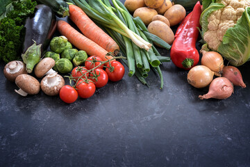Various vegetables on a dark gray slate background, healthy food concept for fitness and lose weight diet, copy space