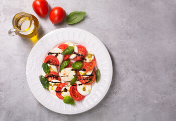 Caprese salad. Italian famous salad with fresh tomatoes, mozzarella cheese and basil