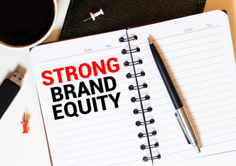 Keyboard of laptop, calcualtor, pencil and notepad with text STRONG BRAND EQUITY on the white background