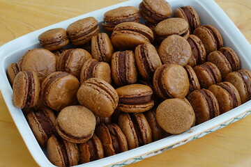 Homemade Chocolate macaron cookies with cocoa dusted on top and ganache filling