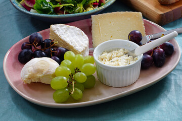View of a cheese platter with fresh grapes