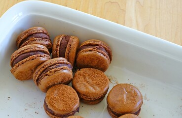 Homemade Chocolate cocoa macaron cookies on a white platter