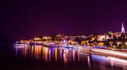 Fototapeta na wymiar Ships dock on Sava river and city centre of Belgrade at night long exposure shot with Kalemegdan and Saborna church