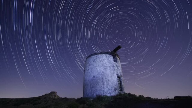 Ruin windmill in the night sky. startrails timelapse. 