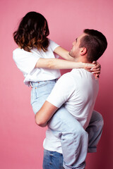 young cheerful caucasian couple together having fun on pink background, guy ang girl modern relationship, lifestyle people concept