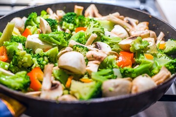 mushrooms and broccoli are prepared in a pan. cooked home food
