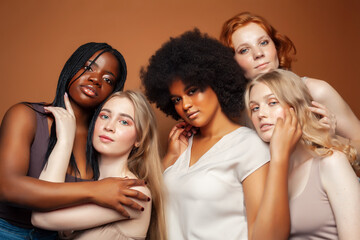 Obraz premium young pretty caucasian, afro, scandinavian woman posing cheerful together on brown background, lifestyle diverse nationality people concept