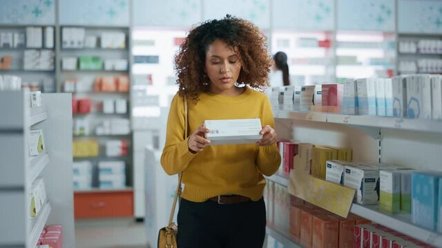 Pharmacy Drugstore: Portrait of a Beautiful Black Young Woman Browsing to Buy Medicine, Chooses Right Package and Smiles Looking at Camera