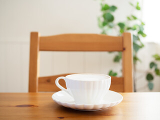 テーブルに置かれたラテの入ったカップ