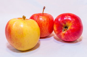 Three red and yellow apples on a white background