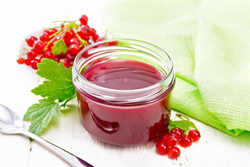 Jam of red currant in jar on board