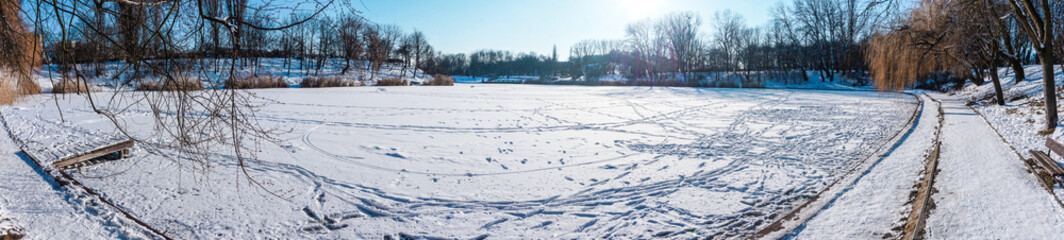 Frozen lake covered with snow in winter - panorama