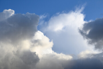 Dramatic and glowing cloudscape of blue sky and white and gray clouds as a nature background
