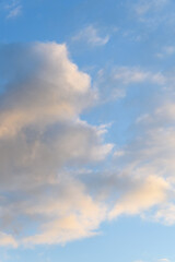 Late afternoon cloudscape, glowing clouds against a blue sky, as a nature background 