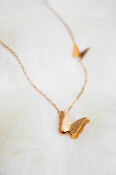 Closeup of a golden necklace with butterflies pendant
