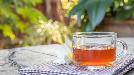 Tea in a clear glass, placed on an old wooden table.