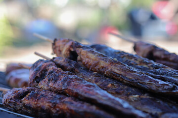 Street food thailand Grilled catfish and roast beef sausages on the grill.