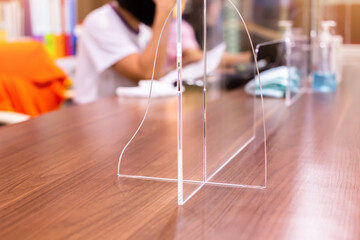 Selective focus to acrylic plastic installed in the office to prevent communicable diseases Coronavirus Covid-19. The concept of installing an antivirus device at counter service.