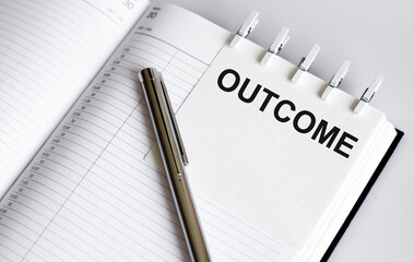text OUTCOME on the short note texture background with pen