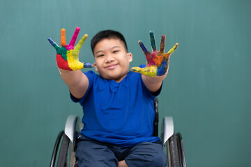 A disabled boy on wheelchair showing hands with colorful colors and smile face