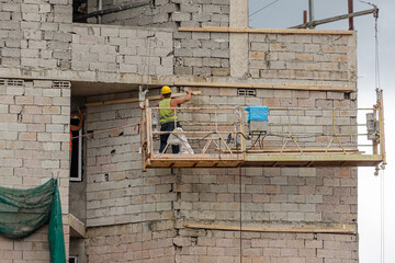 Naklejka premium Construction worker at lifting platform