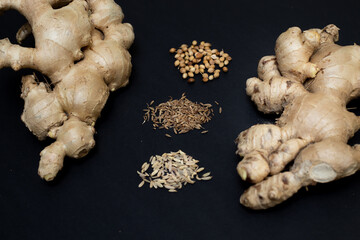 Ginger, cumin, sweet cumin and coriander. Homeopathic herbs, medicines, and remedies. Isolated on black background.