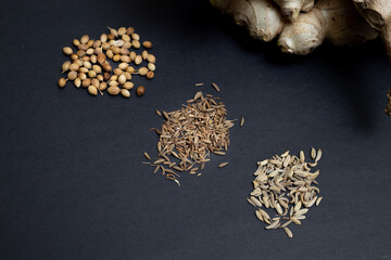 Ginger, cumin, sweet cumin and coriander. Homeopathic herbs, medicines, and remedies. Isolated on black background.