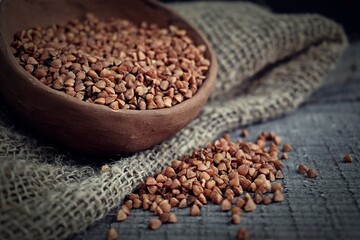 Buckwheat in a clay plate on a wooden background.Healthy food.