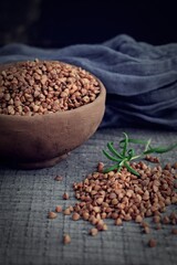 Buckwheat in a clay plate on a wooden background.Healthy food.