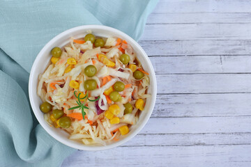 Salad of fresh cabbage with green peas and corn.