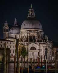 Fototapeta na wymiar Night view of the church of Santa Maria della Salute with its prominent domes on the Gran Canal, Venice, Italy
