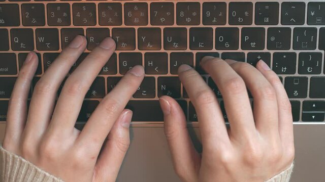Top overhead view fingers of young woman typing on laptop keyboard.