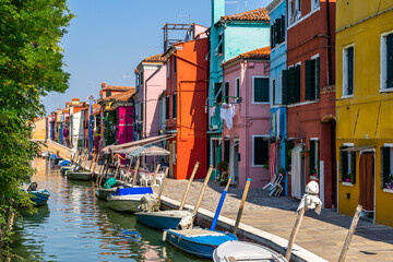 Fototapeta na wymiar Typical bright colorful houses in Burano along a canal, Italy