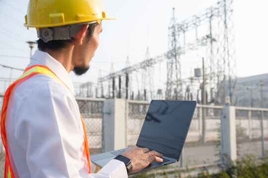Engineer hold laptop computer inspection on site power plant high volte system