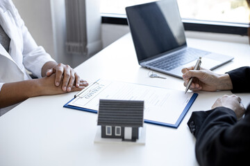 The home salesman and buyer is signing a purchase agreement after discussing the details, a contract to protect both parties' interests if the trade is not as agreed, Real estate trading ideas.