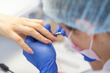 Professional manicure. Closeup shot of a woman in a nail salon. Professional nail polish with electric tips, selective focus