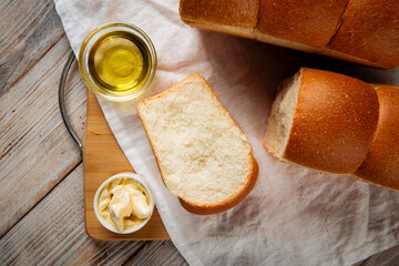 Top view on cut fresh baked shaped wheat bread with butter and coffee