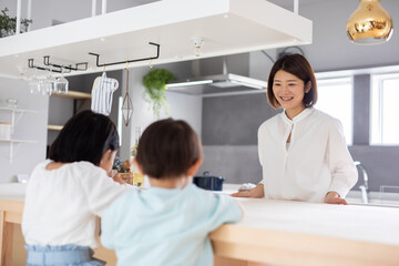 Fototapeta premium 母親と二人の子供がキッチンのテーブルで過ごしている mother kitchen kids