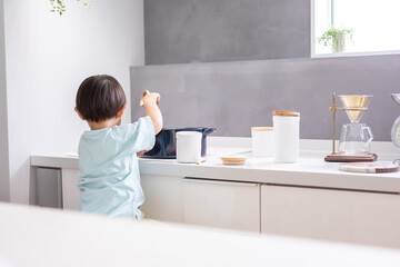 白いキッチンで男の子が青い鍋で料理をしている　boy kitchen 