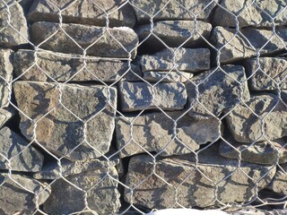 fence made of gabions, rock fence. texture of the gabion fence is made of natural stone and metal mesh