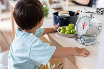 キッチンで男の子が秤を使って食べ物を計っている　kitchen kids Scale