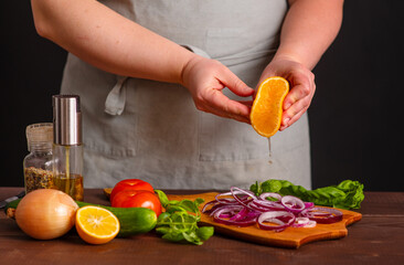 The cook pickles the red onion with lemon juice, squeezing it onto the chopped onion. Frozen lemon juice motion in flight. Cooking a burger.