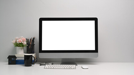 Front view of simple workspace with modern computer and office supplies. Blank screen for your text or advertising content