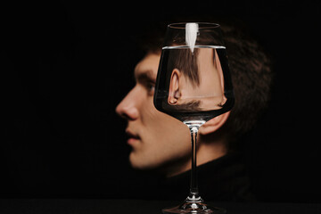 portrait of a man in profile through a glass of water