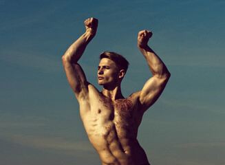 Man with glitter on bare chest. Athletic bodybuilder pose as hercules. Gladiator or atlant. Man...